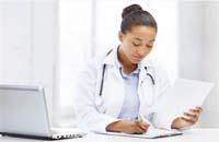 Female doctor with a prinout and a laptop